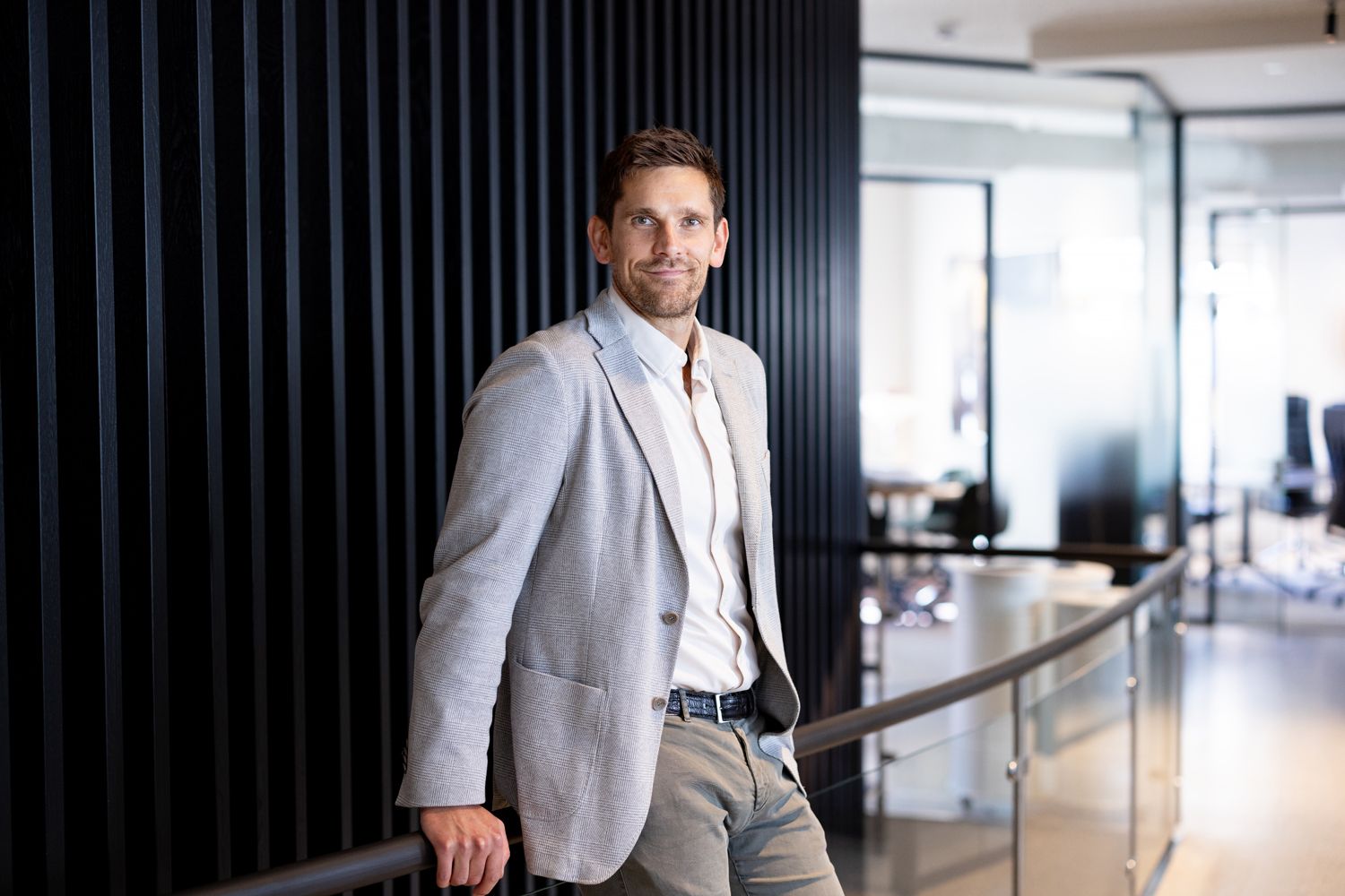 Mann i dress smiler i kamera