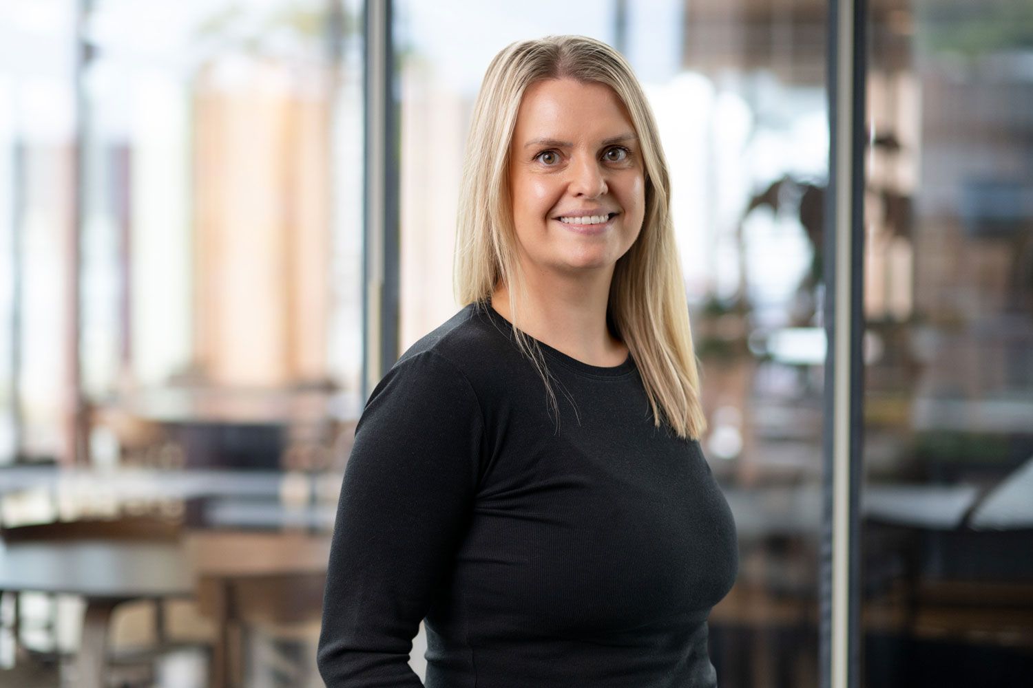 Dame med lyst hår er blid og smiler til kamera