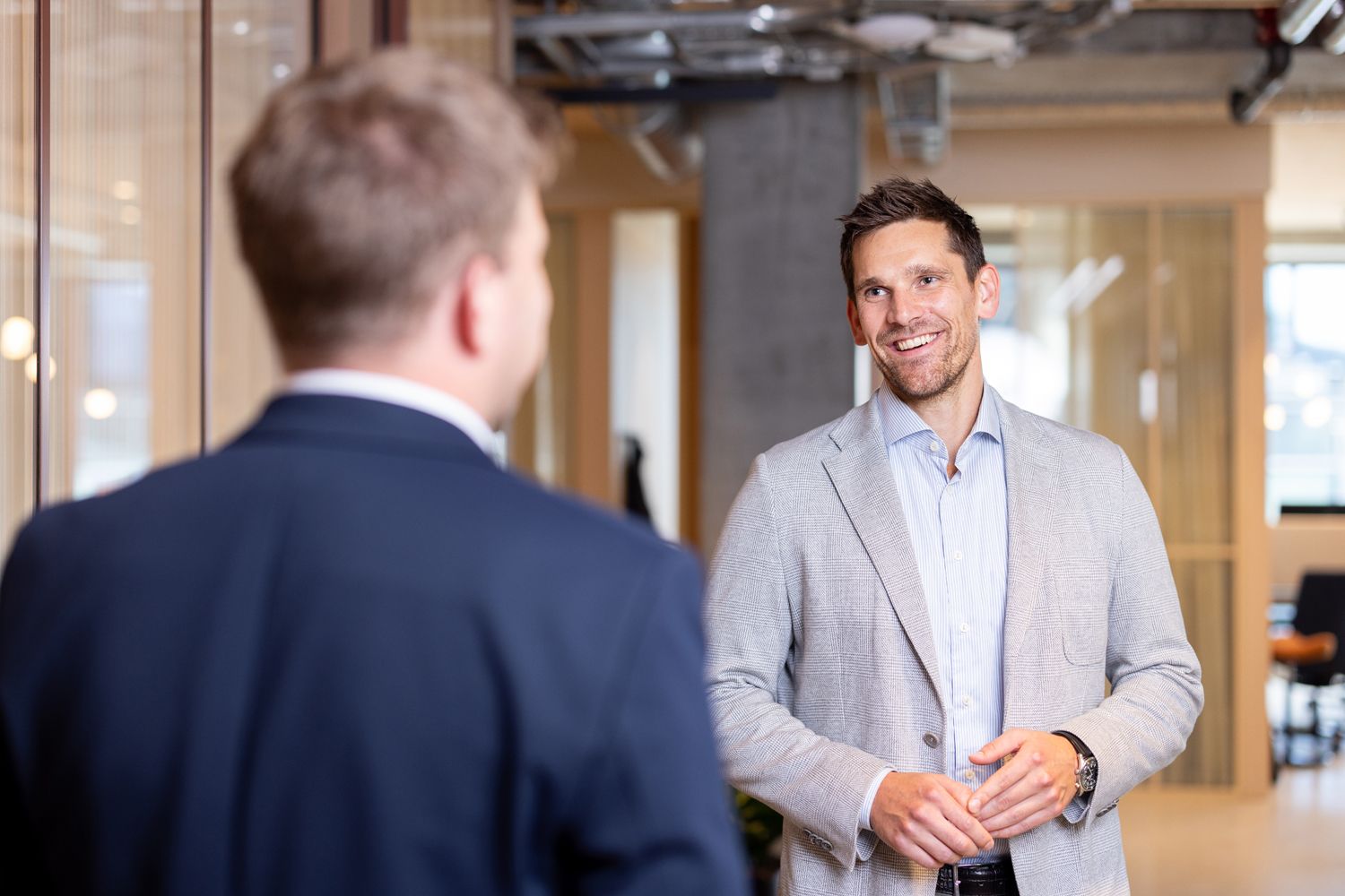 Mann i dress smiler i kamera