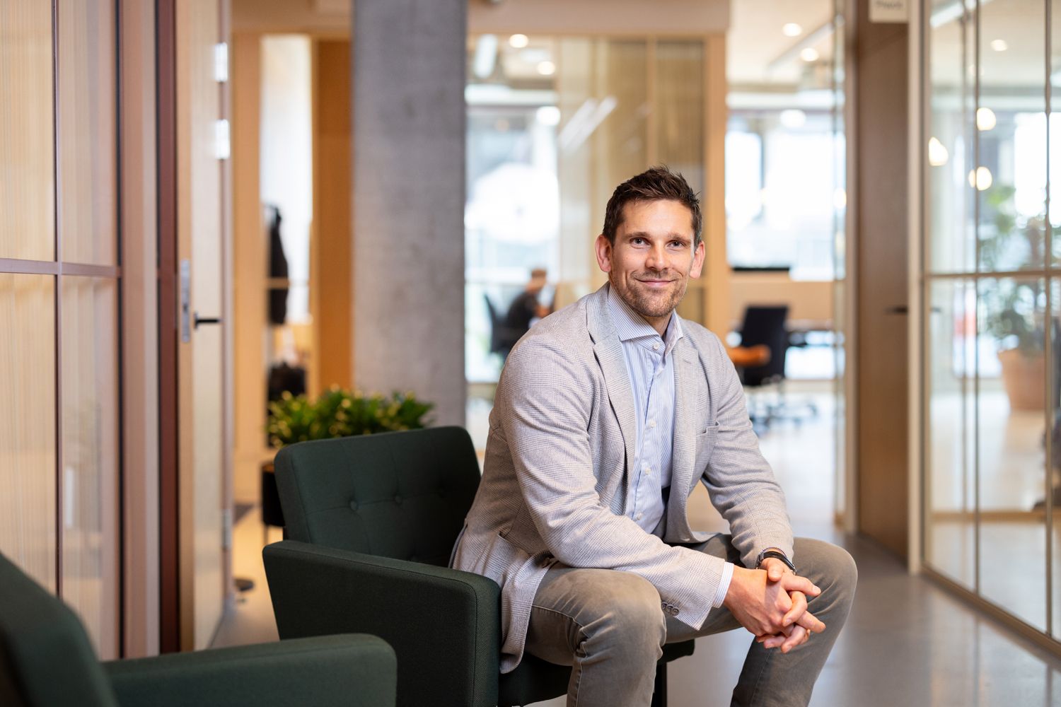 Mann i dress smiler i kamera